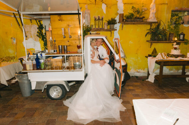 Intimate Celebration: Katelyn and Dave’s Wedding Day Embrace at Gulf Port, St. Pete Beach Newlyweds Katelyn and Dave share a romantic embrace inside a vintage mobile bar at their Gulf Port Saint Pete Beach wedding