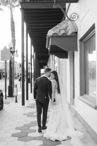 Hailey walks down Hotel Haya’s Los Navidades aisle, lace veil flowing. Tampa wedding photography by Stills by Hernan, venue @hotelhaya